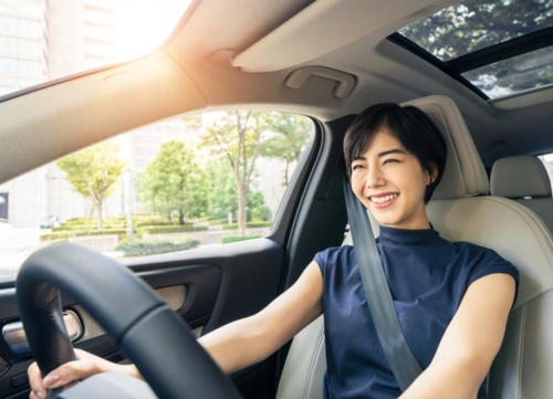 A happy woman drives her company car